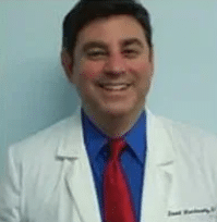 Dr. David Markowitz Photo of Dr. David Markowitz, chiropractor at Sarasota Medical Injury Center: Mankowitz Chiropractic and Massage, smiling and wearing a dress shirt, tie and medical jacket.