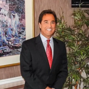 Dr. Vincet Preziosi Photo of Dr. Vincent Preziosi, a chiropractor at East Orlando Medical Injury Center in Orlando, Florida, posing with hands together in front of him and wearing a dark suit and tie.