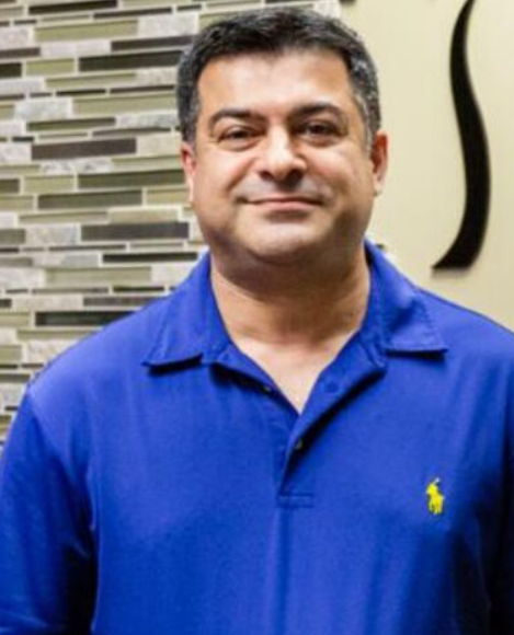 Heashot photo of Dr. Mohammad Hamtaee, chiropractor at Lakeland Medical Injury Centers: Florida Spine & Injury Center, smiling and wearing a blue polo shirt.