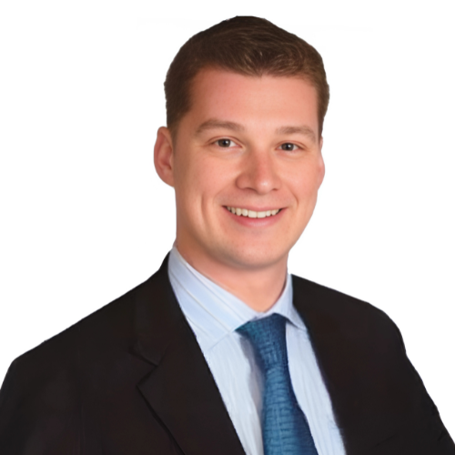 Heashot photo of Dr. Devin Perdue, chiropractor at Palm Harbor Medical Injury Centers: Atlas Clinic, smiling and wearing a tie, dress shirt and jacket.