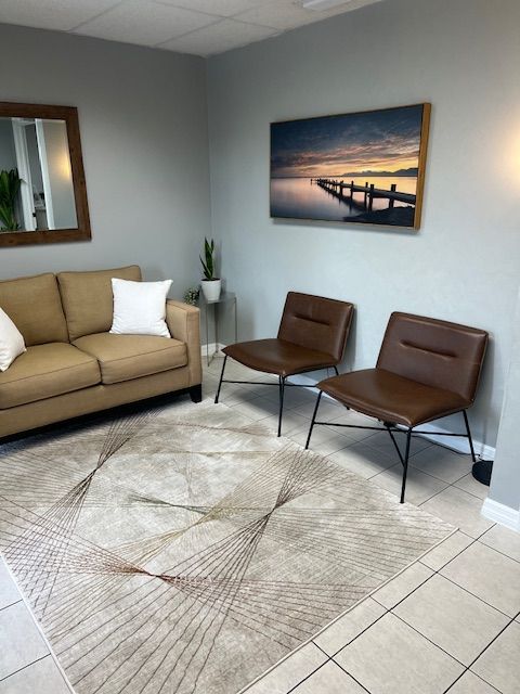 View of waiting area with Sofa on far wall and two chairs on right wall at St. Petersburg Medical Injury Center: Rainey Chiropractic