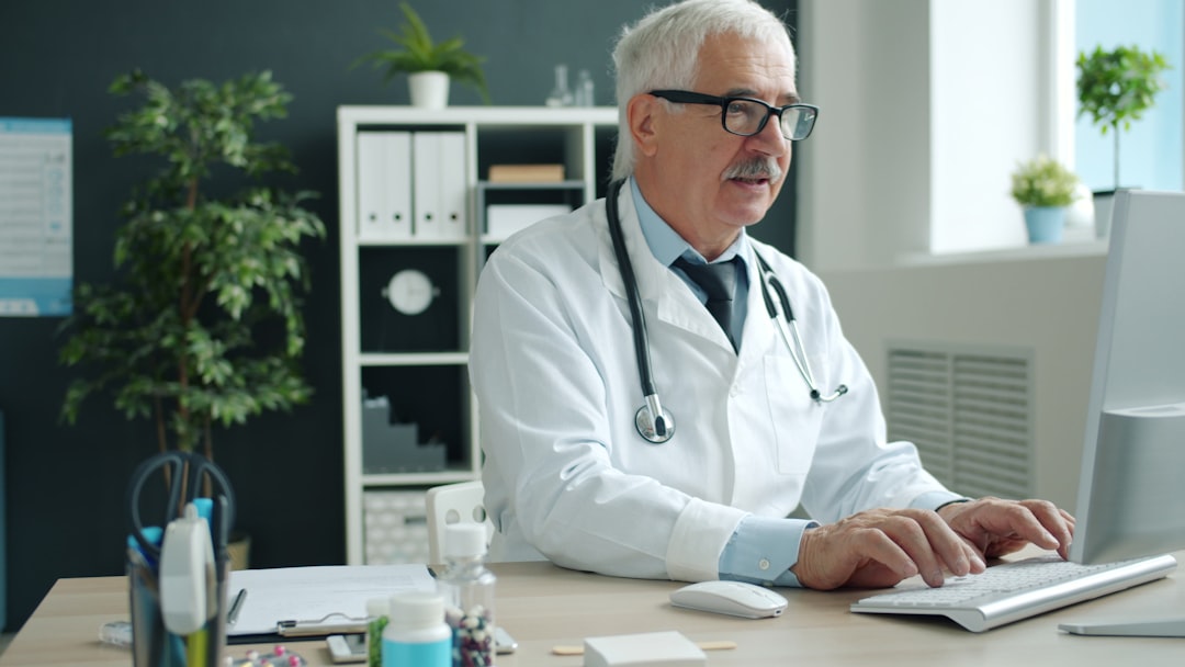 Physician working at a computer coordinating patient care