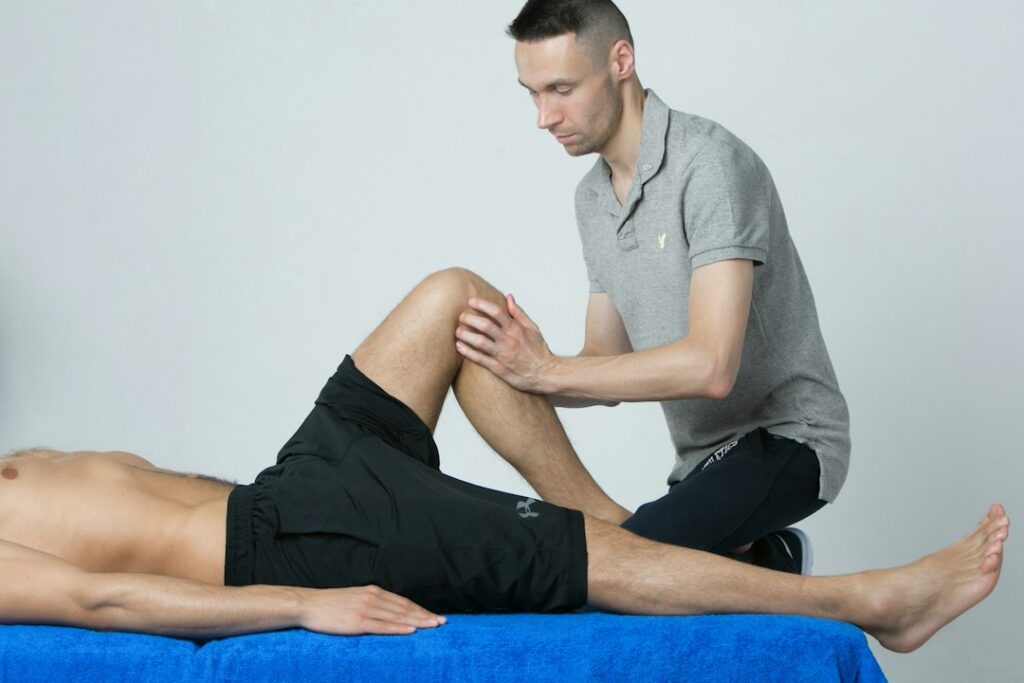 Clinician examining a patient's leg in a rehabilitation setting